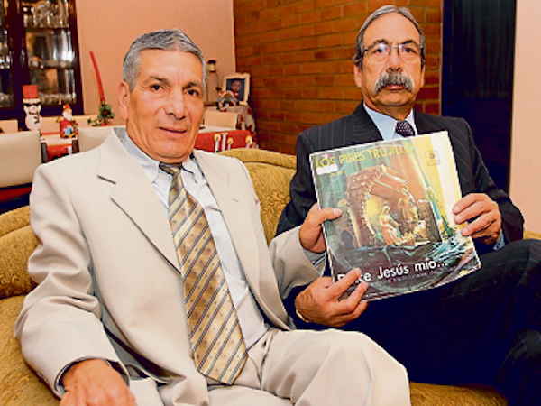 Los hermanos Luis y Juan Trujillo, junto a su fallecido hermano Gustavo, grabaron en su infancia el disco de m&uacute;sica navide&ntilde;a tradicional ecuatoriana m&aacute;s popular de la historia, el cual sostienen en esta gr&aacute;fica.