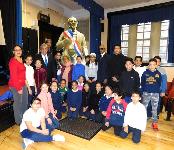 El c&oacute;nsul Carlos Castillo, a la izquierda, junto a estudiantes y la principal de la escuela Juan Pablo Duarte, Xiomara Nova, la activista comunitaria Carmen Rojas y Bienvenido Lara Flores, del Instituto Duartiano, entre otros. 