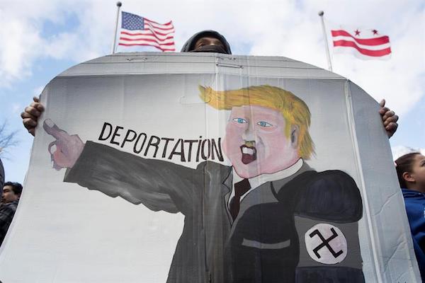 Un manifestante sostiene un dibujo en el que se representa al presidente estadounidense Donald Trump usando un brazalete de esvástica, durante una marcha realizada en apoyo al evento "Un Día Sin Inmigrantes".