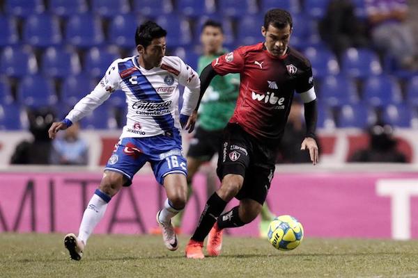 José Toledo (i) del Puebla FC disputa el balón contra Rafael Márquez (d) de Atlas.