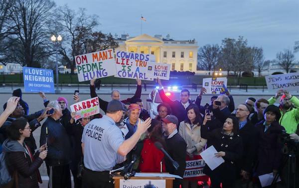 Un policía del parque intenta controlar una protesta contra la orden ejecutiva revisada del presidente estadounidense, Donald J. Trump, que prohíbe las visas de viaje de seis países de mayoría musulmana, hoy, lunes 6 de marzo de 2017, en el parque Lafayette, en Washington DC .