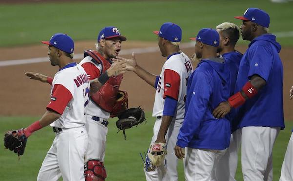 El receptor de Puerto Rico, Yadier Molina (2-L), celebra a sus compañeros tras vencer a Estados Unidos en la segunda ronda para avanzar a las semifinales del Clásico Mundial de Béisbol.