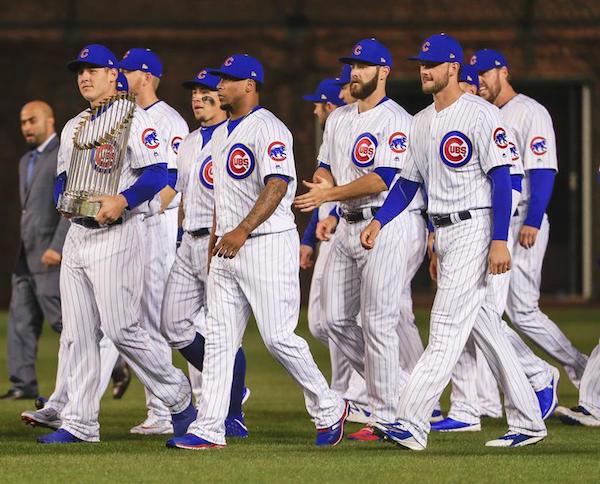 El jugador de Cachorros Anthony Rizzo (i) sostiene el trofeo de la Serie Mundial de B&eacute;isbol hoy, lunes 10 de abril de 2017, antes de un partido entre Dodgers y Cachorros por la MLB, en el Wrigley Field de Chicago, Illinois.