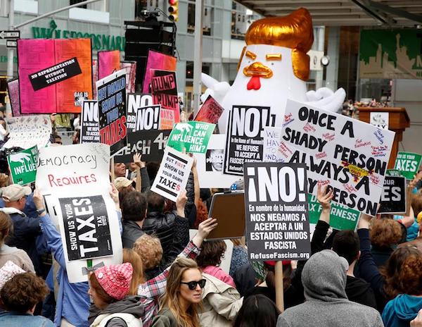 Los manifestantes sostienen se&ntilde;ales durante una marcha de protesta del D&iacute;a de los Impuestos en las afueras de Bryant Park en Nueva York, Nueva York, Estados Unidos, el 15 de abril de 2017. La protesta marchar&aacute; hasta la Torre Trump en la Quinta Avenida.