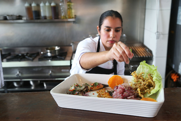  Fotograf&Igrave;a de una de las cocineras del restaurante La Picanter&Igrave;a , terminando de preparar un tradicional plato de ceviche . La Picanter&Igrave;a es la propuesta de una cocina que recrea los tradicionales locales de la costa peruana .