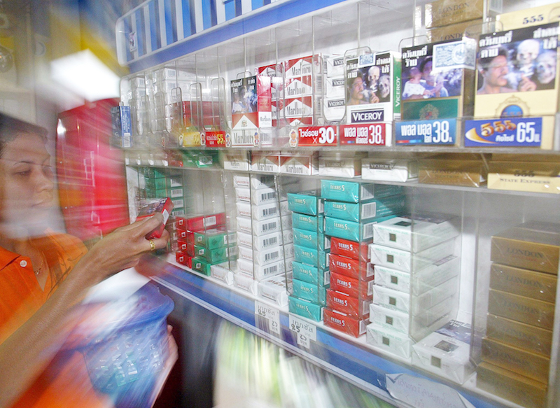 Una vendedora  quita los paquetes de cigarrillos de unas estanter&iacute;as en una tienda. El d&iacute;a 31 es el D&iacute;a Sin Tabaco en todo el mundo.