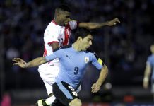 El jugador de Uruguay Luis Suárez (d) disputa el balón con Carlos Ascuez (i) de Perú en un partido contra Perú por las eliminatorias suramericanas para Rusia 2018 en el estadio Centenario de Montevideo, Uruguay.
