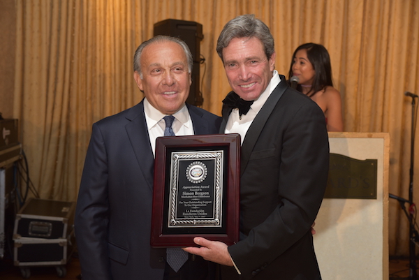 El señor John Wind, presidente de Porky's, hace entrega de la placa de reconocimiento al señor Simón Bergson, Presidente y CEO de Cerveza Manhattan por su empresa obtener el galardón como compañía del año.