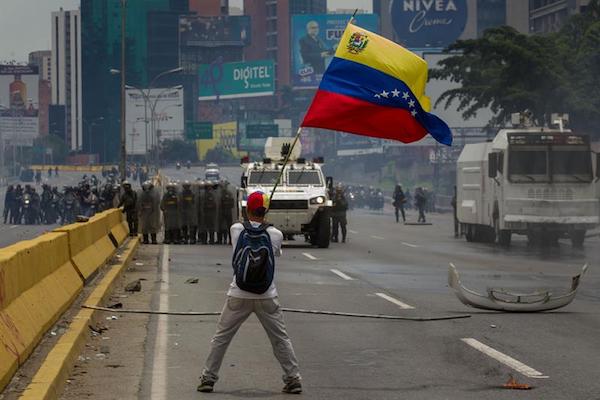 Un manifestante devuelve una bomba de gas lacrim&oacute;geno a la polic&iacute;a durante una protesta opositora hoy, martes 30 de mayo de 2017, en Caracas (Venezuela). 