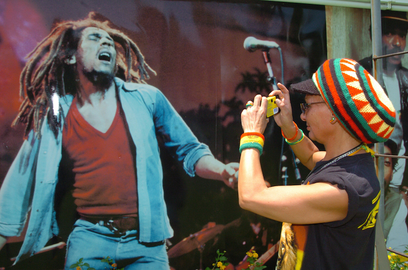 Una seguidora del cantante jamaicano Bob Marley, fotografía un póster del artista en Kingston (Jamaica).