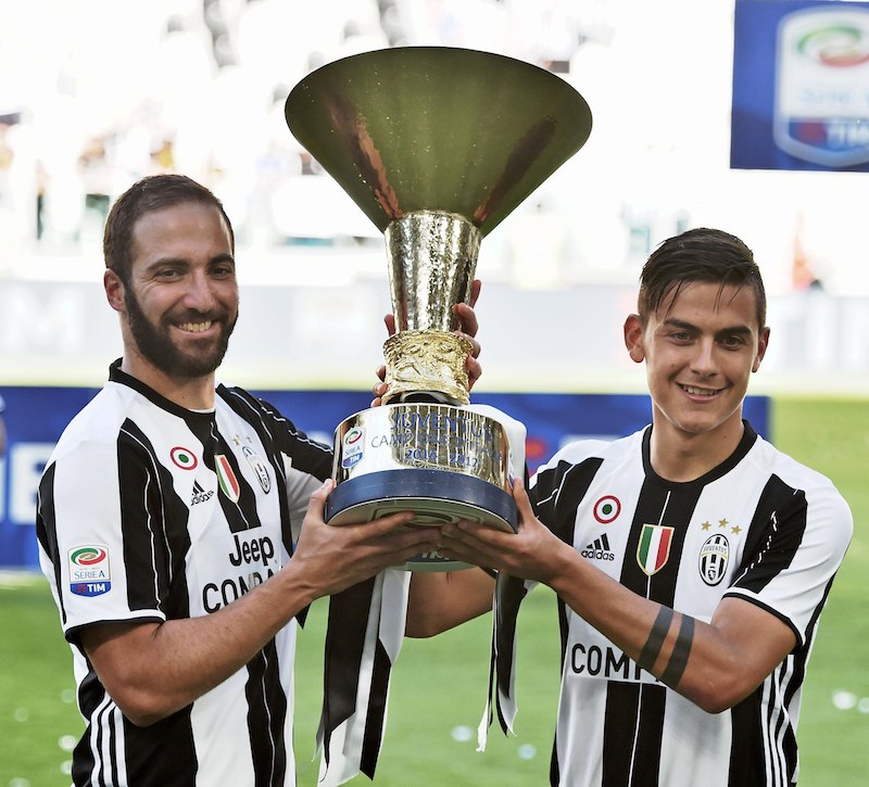 Los argentinos Gonzalo Higuain (izquierda) y Paulo Dybala, la delantera del Juventus, posan con el “Scudetto” conseguido por el club de Turín, el pasado 21 de mayo.