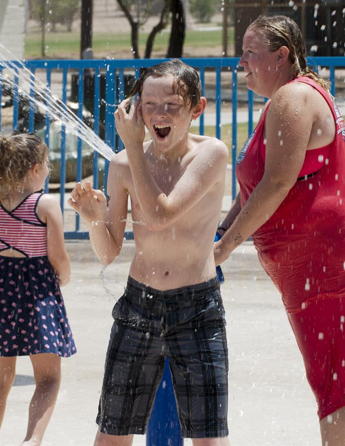 Niños juegan con chorros de agua en un parque en Tucson, AZ. La ola de calor obligó a suspender casi 50 vuelos en Phoenix, ciudad de Arizona enclavada en una zona donde han muerto desde abril cuatro personas a causa del calor