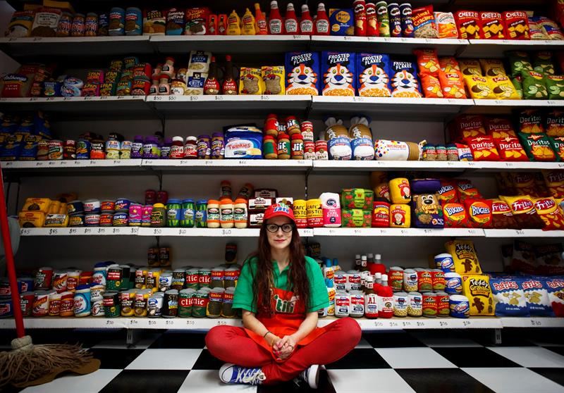 Una dependienta posa junto a los art&iacute;culos que forman parte de la obra del artista brit&aacute;nico Lucy Sparrow titulada 'Ocho, como tarde' que reproduce 9.000 objetos que puedes encontrarte en un super mercado, pero hechos de fieltro en Nueva York.