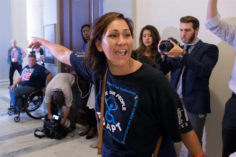 La polic&iacute;a del Capitolio desaloja a una manifestante a las afueras de la oficina del l&iacute;der de la mayor&iacute;a en el Senado, el republicano Mitch McConnell, en Washington DC 