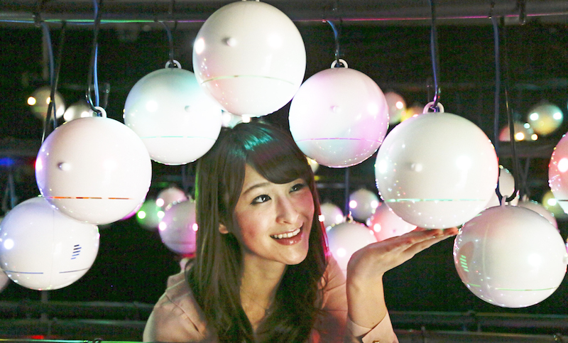 La presentadora del tiempo japonesa Sayaka Kawamura posa junto a varios robots que miden los niveles de polen en el país.