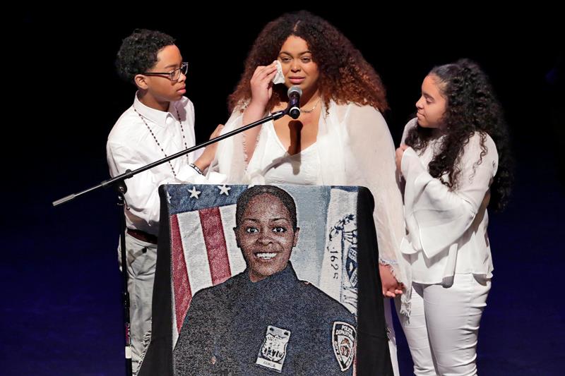 Genesis Villella (c) abraza a los gemelos, Delilah y Peter Vega, hijos de la polic&iacute;a asesinada Miosotis Familia durante su funeral en una iglesia del Bronx, Nueva York 