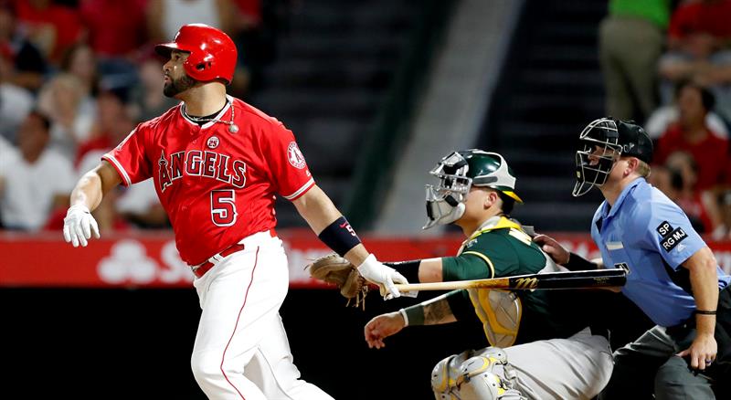 El jugador de Los Angelinos de Los &Aacute;ngeles de Anaheim Albert Pujols (i) y Bruce Maxwell (c) de los Atl&eacute;ticos de Oakland observan la pelota lanzada por Pujols el mi&eacute;rcoles 30 de agosto de 2017, en un partido de la MLB entre Los Angelinos de Los &Aacute;ngeles de Anaheim y Atl&eacute;ticos de Oakland, en el estadio Angel en Anaheim