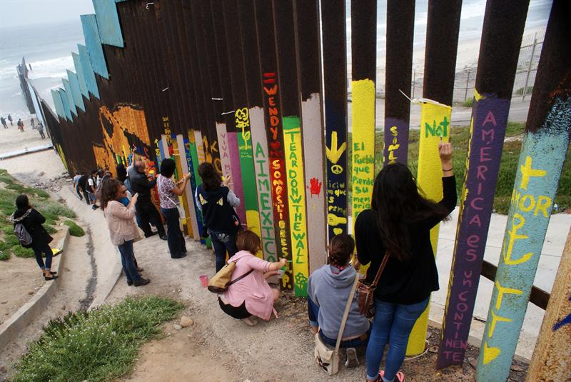 Ciudadanos mexicanos pintan el muro fronterizo entre M&eacute;xico y Estados Unidos  en Tijuana (M&eacute;xico).