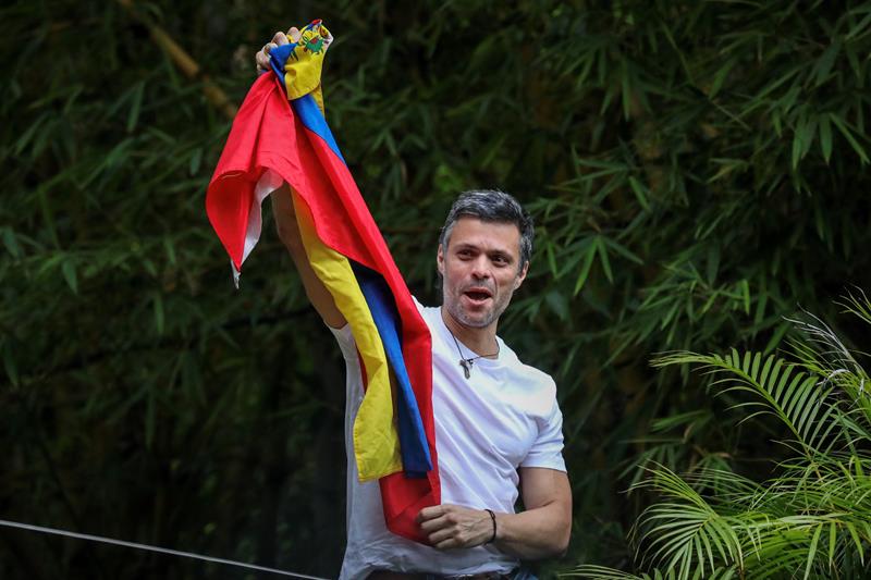 El opositor venezolano Leopoldo L&oacute;pez saluda a seguidores en la entrada de su casa en Caracas (Venezuela).