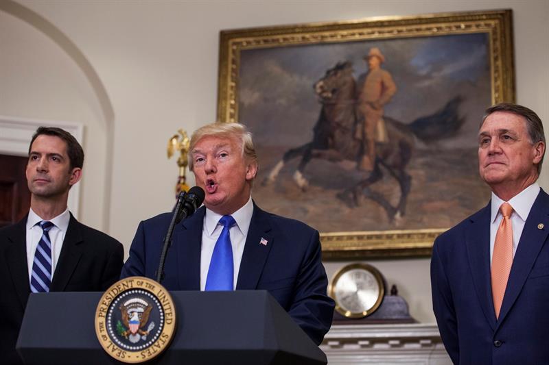 El presidente de EEUU, Donald Trump (c), avala la Ley de Reforma de la Inmigraci&oacute;n Estadounidense para un Empleo Fuerte (RAISE, que significa "incrementar", en ingl&eacute;s), junto al senador republicano de Arkansas, Tom Cotton (i), y junto al senador republicano de Georgia, David Perdue (d), en un acto en la Casa Blanca en Washington