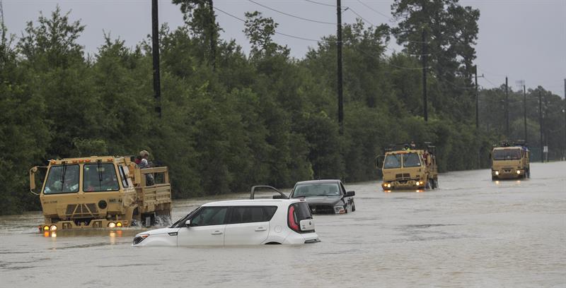 Camiones de la Guardia Nacional de Texas que llevan a v&iacute;ctimas de inundaciones pasan junto a veh&iacute;culos sumergidos despu&eacute;s del paso del hurac&aacute;n Harvey en Houston, Texas