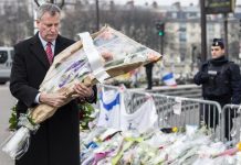 El alcalde de Nueva York, Bill de Blasio, porta un ramo de flores durante su visita al supermercado "kosher" de París en el que cuatro personas perdieron la vida el pasado 9 de enero tras ser tomados como rehenes por un terrorista