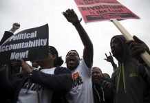 Varias personas celebran el anuncio de la Fiscalía del estado de Maryland de que presentará cargos contra seis agentes de la Policía de Baltimore por la muerte del joven negro Freddie Gray,