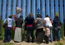 María del Carmen Laguna, de 61 años (2-i), habla con una de sus hijas a través de la malla metálica hoy, domingo 10 de mayo de 2015, en la frontera entre Tijuana (México) y San Diego (California).