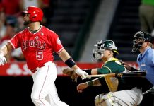 El jugador de Los Angelinos de Los Ángeles de Anaheim Albert Pujols (i) y Bruce Maxwell (c) de los Atléticos de Oakland observan la pelota lanzada por Pujols el miércoles 30 de agosto de 2017, en un partido de la MLB entre Los Angelinos de Los Ángeles de Anaheim y Atléticos de Oakland, en el estadio Angel en Anaheim