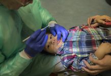 Ray Stewart, profesor de odontología pediátrica en la Universidad de California en San Francisco examina a Matthew Mai, de 2 años, de Vallejo, California. Stewart ha estado tratando a niños pequeños por 15 años. (Robert Durell para Kaiser Health News)