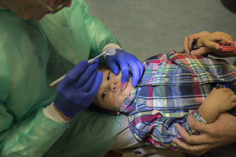 Ray Stewart, profesor de odontolog&iacute;a pedi&aacute;trica en la Universidad de California en San Francisco examina a Matthew Mai, de 2 a&ntilde;os, de Vallejo, California. Stewart ha estado tratando a ni&ntilde;os peque&ntilde;os por 15 a&ntilde;os. (Robert Durell para Kaiser Health News)