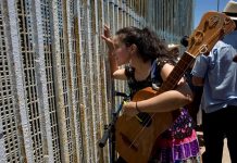 El muro de Trump con México: solo 120 kilómetros para una frontera de 3.180 Una mujer habla con alguien tras la reja que separa la frontera entre México y EE.UU.