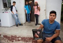 Francisco Duarte Jr., de 19 años (d) enseña una fotografía de sus padres acompañado por dos de sus hermanos Yarely (2i) y Aracely (2d) de 12 años y Luis Duarte de 17 años (i).