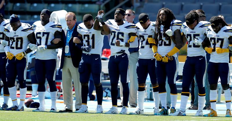 Dean Spanos (3-L), de Los Angeles Chargers, est&aacute; de brazos cruzados con su equipo durante el Himno Nacional antes de su partido de f&uacute;tbol de la NFL contra los Kansas City Chiefs