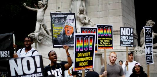 Un pequeño grupo de personas se reúnen con carteles para protestar contra la decisión del Tribunal Supremo de Estados Unidos de restablecer una parte de la orden ejecutiva del presidente de EE.UU., Donald Trump, que prohíbe que personas de ciertos países viajen a Estados Unidos, hoy, lunes 26 de junio de 2017, en Nueva York.