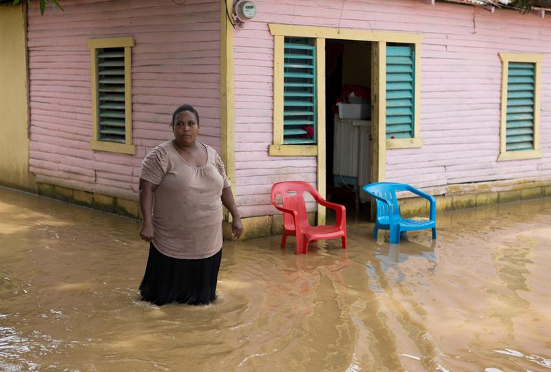 Una mujer camina por una calle inundada hoy, viernes 22 de septiembre de 2017, tras el paso del huracán María en la ciudad de Nagua (República Dominicana).