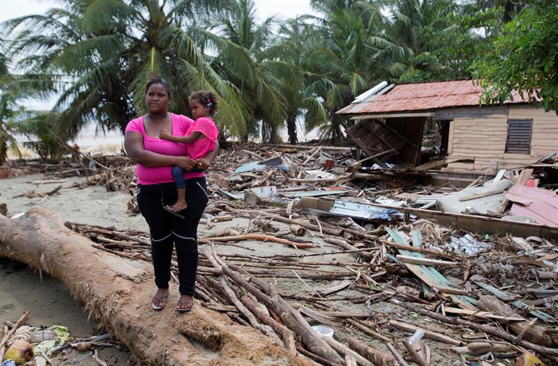Una mujer sostiene a una niña en brazos mientras observa los daños causados por el paso del huracán María hoy, viernes 22 de septiembre de 2017, en la ciudad de Nagua (República Dominicana).