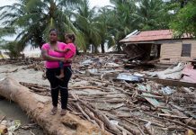 Una mujer sostiene a una niña en brazos mientras observa los daños causados por el paso del huracán María hoy, viernes 22 de septiembre de 2017, en la ciudad de Nagua (República Dominicana).