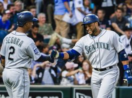 El jugador de los Marineros de Seattle Robinson Cano (D) de la República Dominicana celebra con el jardinero de los Marineros de Seattle, Jean Segura (I) de la República Dominicana después de conducirlo y el receptor de los Marineros de Seattle Mike Zunino con un triunfo en la tercera entrada del béisbol MLB Juego entre los Marineros de Seattle y los Medias Blancas de Chicago en el Campo de Tarifa Garantizada en Chicago, Illinois.