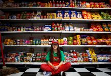 Una dependienta posa junto a los artículos que forman parte de la obra del artista británico Lucy Sparrow titulada 'Ocho, como tarde' que reproduce 9.000 objetos que puedes encontrarte en un super mercado, pero hechos de fieltro en Nueva York.