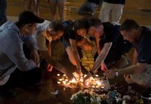 La gente coloca velas mientras se reúnen durante una vigilia en Charlottesville, Virginia,