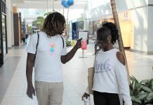 Maya Terrell, a la derecha, camina con Lamarr Morris en el centro comercial Arden Fair de Sacramento el 19 de junio. (Kellen Browning / California Healthline)