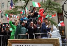 Un grupo de personas con banderas italianas ver pasar el Desfile Anual del Columbus Day, en Nueva York