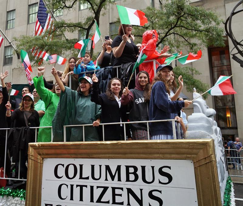 Un grupo de personas con banderas italianas ver pasar el Desfile Anual del Columbus Day, en Nueva York