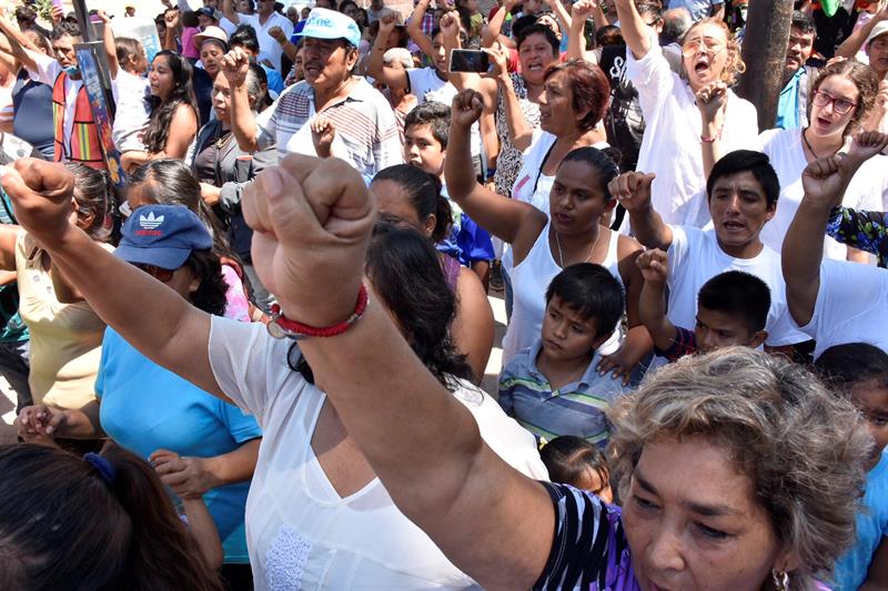 Habitantes de la ciudad de Jojutla, en el estado de Morelos (México), levantan sus puños mientras guardan tres minutos de silencio hoy, jueves 19 de octubre de 2017, para recordar a las víctimas del terremoto que sacudió al país exactamente hace un mes y que causó 369 fallecidos.