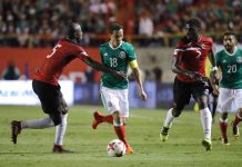 Andrés Guardado disputa el balón con Daneil Cyrus de Trinidad y Tobago.