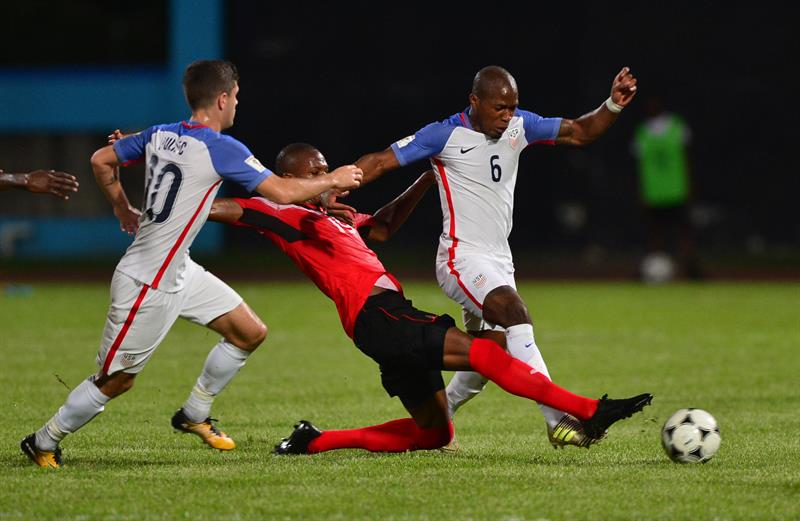 Christian Pulisic (i) y Matt Besler (d) de Estados Unidos disputan el bal&oacute;n con Kevan George (i) de Trinidad y Tobago durante un partido de clasificaci&oacute;n para el Mundial de Rusia 2018 hoy, martes 10 de octubre de 2017, en el Estadio Ato Boldon de Couva (Trinidad y Tobago).