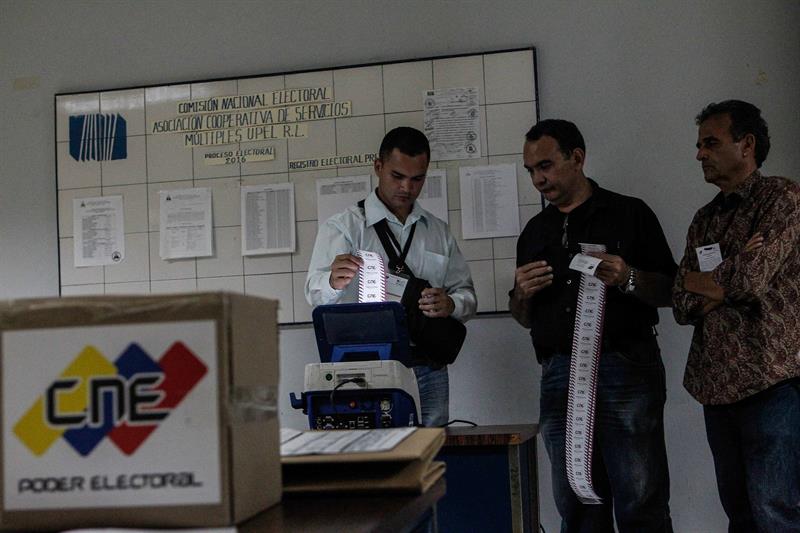 Miembros de mesa y testigos participan en el cierre de mesas y auditor&iacute;a de actas, en un centro electoral tras las elecciones regionales el pasado domingo 15 de octubre de 2017, en Caracas (Venezuela). 