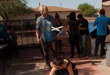Miembros de la Coalición de los Derechos Humanos de Arizona se reúnen para pintar y decorar 147 cruces de madera.