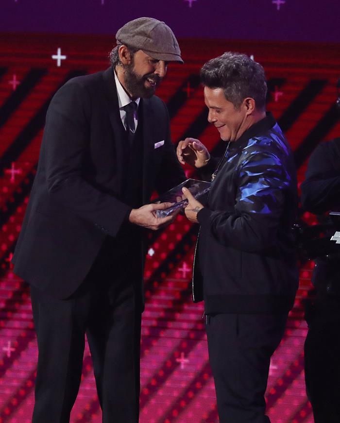 El cantante Alejandro Sanz (d) recibe el reconocimiento a "Persona del A&ntilde;o" por parte del cantante dominicano Juan Luis Guerra durante los XVIII Premios Grammy Latinos